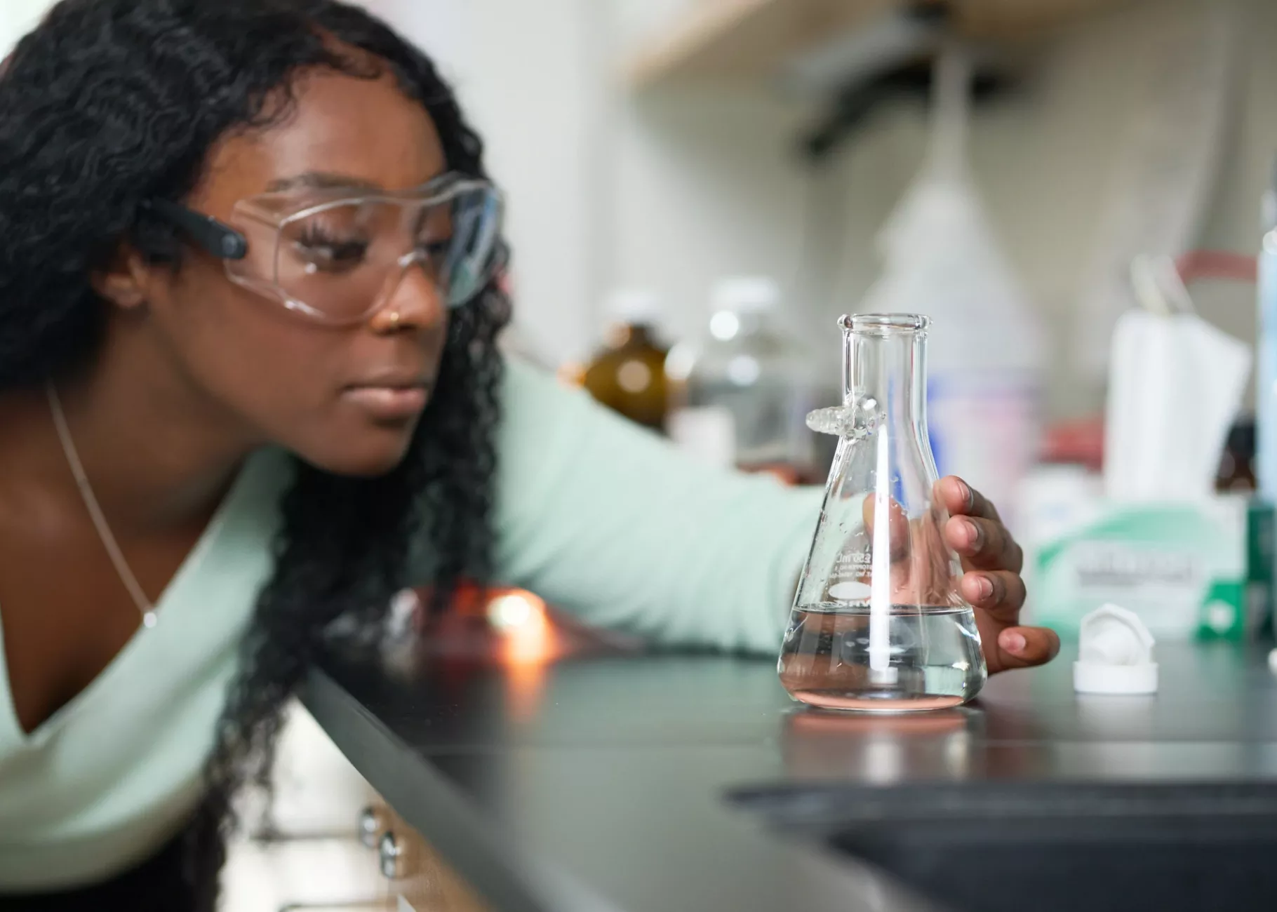 Female student performs chemistry experiment in a lab