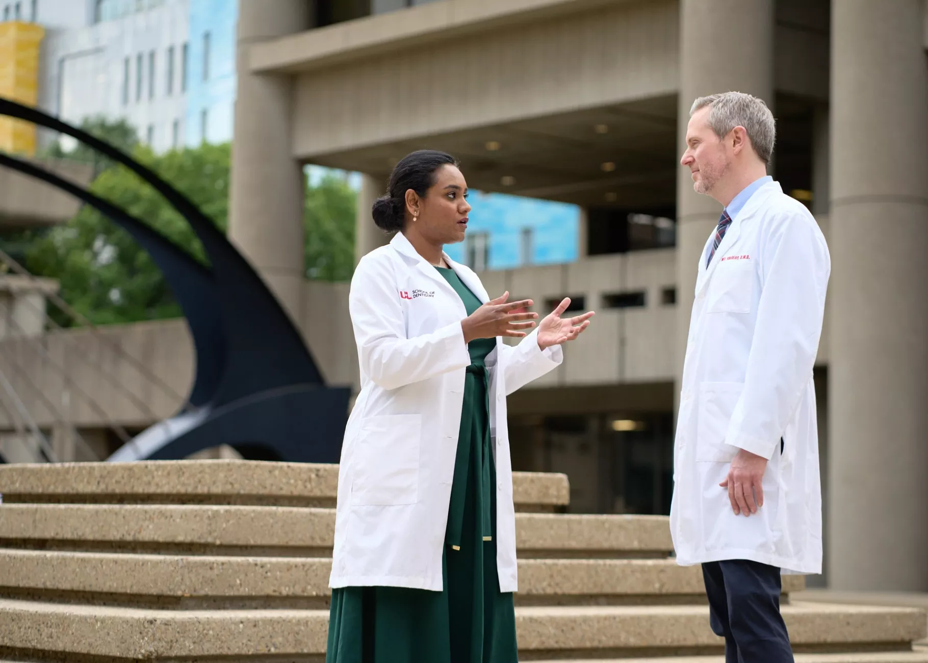 Female and male doctor having a conversation on HSC campus.