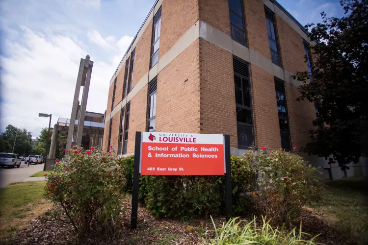 red and white sign in front of building that says University of Louisville School of Public Health and Information Sciences,…