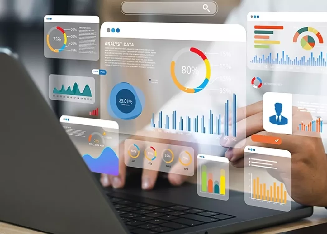Stock photo of person typing on a computer showcasing different graphs and charts