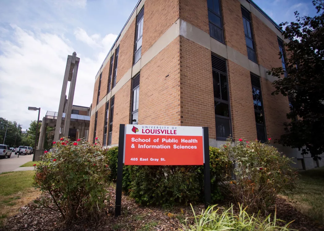 red and white sign in front of building that says University of Louisville School of Public Health and Information Sciences,…