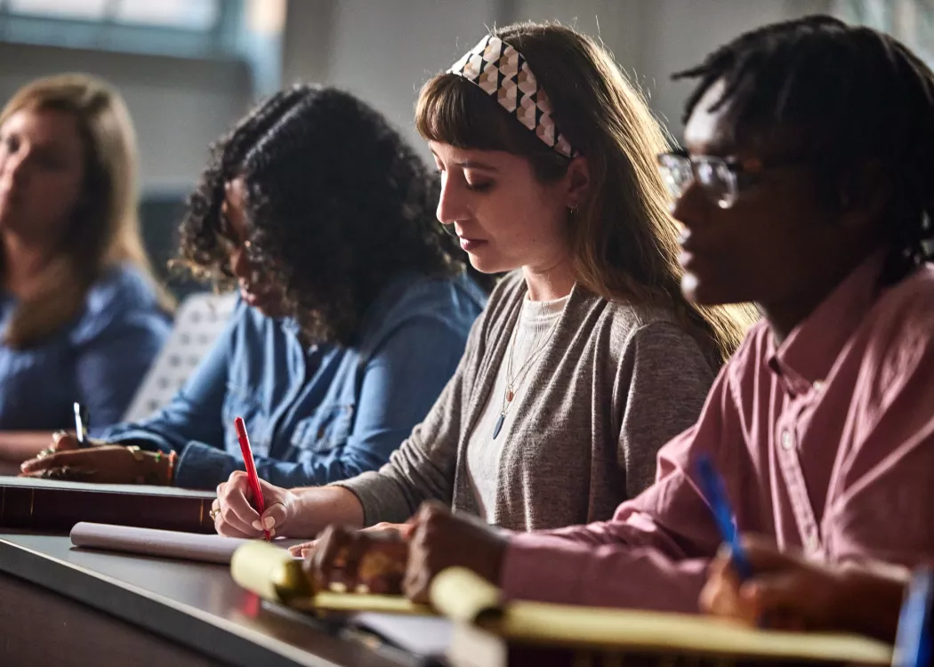 Multiple law students are listening to the lecture and engaging with the lecture through active attention and taking notes.
