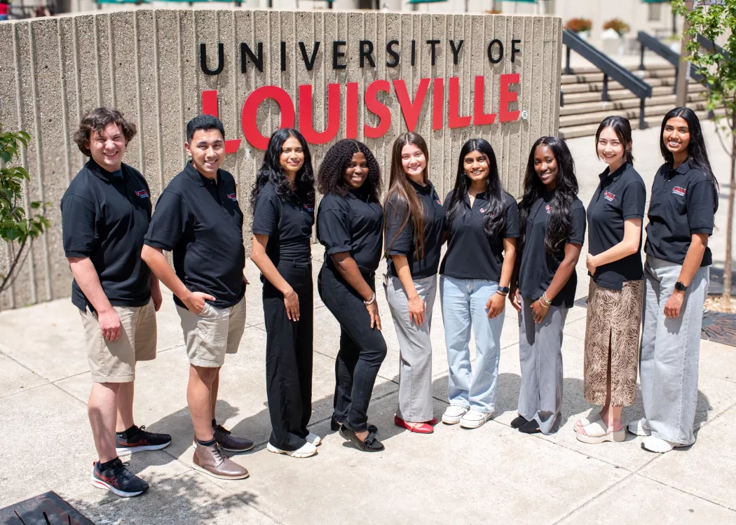 SPHIS Student Ambassadors smiling in front of the University of Louisville sign on the HSC campus