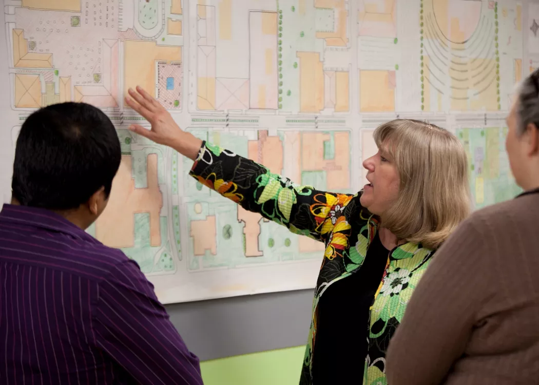 Public Health faculty pointing to a map for city planning