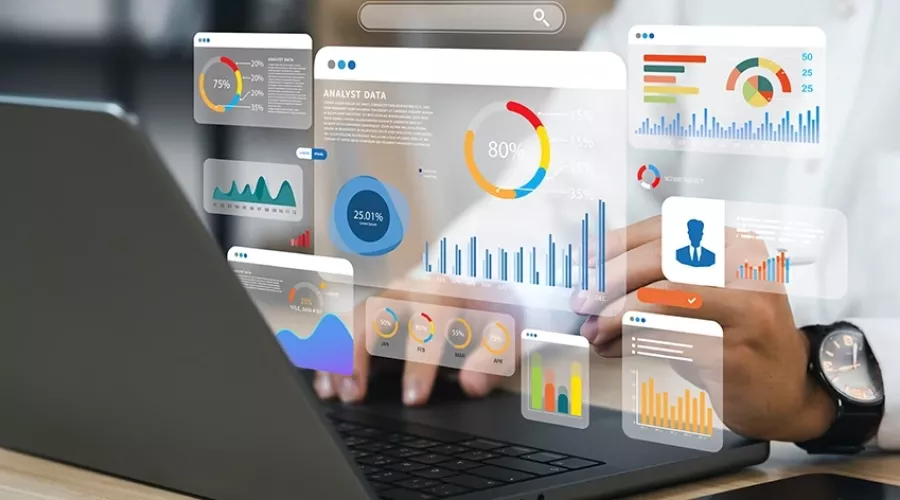 Stock photo of person typing on a computer showcasing different graphs and charts