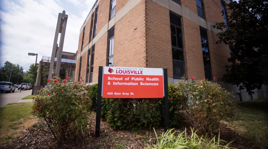 red and white sign in front of building that says University of Louisville School of Public Health and Information Sciences,…